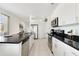 Modern kitchen with white cabinets, granite countertops, and stainless steel appliances at 470 Lake Shore Pkwy, Davenport, FL 33896