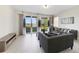 Living room with gray sofas, coffee table, and sliding glass doors leading to a patio with water views at 470 Lake Shore Pkwy, Davenport, FL 33896