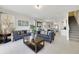 Open living room with gray sofas, a coffee table, and views into the kitchen and dining area at 470 Lake Shore Pkwy, Davenport, FL 33896