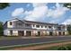 Exterior view of townhouses with gray and white siding and brick driveways at 5084 Rain Shadow Dr, St Cloud, FL 34772