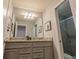 Double vanity bathroom with granite countertop and gray cabinets at 7400 Oakmoss Loop, Davenport, FL 33837