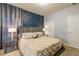 Bright bedroom with a comfortable bed and geometric accent wall at 7400 Oakmoss Loop, Davenport, FL 33837