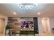 Game room with a large TV, rustic wood wall, and comfortable seating at 7400 Oakmoss Loop, Davenport, FL 33837