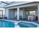 Screened patio with pool, spa, and outdoor furniture at 7400 Oakmoss Loop, Davenport, FL 33837