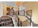 Grand staircase with ornate railing and chandelier at 7440 Aloma Ave, Winter Park, FL 32792