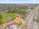 Aerial view of commercial property situated on a busy road with nearby businesses and a pond at 7440 Aloma Ave, Winter Park, FL 32792