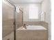 Bathroom with soaking tub, walk-in shower, and tile flooring at 7766 Westland Dr, Kissimmee, FL 34747