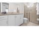 Bathroom with granite countertop, white cabinets, and a shower at 7766 Westland Dr, Kissimmee, FL 34747