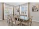Bright dining room with large glass table and eight beige chairs at 7766 Westland Dr, Kissimmee, FL 34747