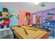 Fun game room with pool table, ping pong, and playful Disney theme at 7766 Westland Dr, Kissimmee, FL 34747