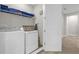 Convenient laundry room with washer, dryer, and shelving at 7766 Westland Dr, Kissimmee, FL 34747