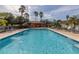 Community pool with lounge chairs and shaded seating area at 836 Grand Canal Dr, Kissimmee, FL 34759