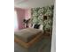 Bedroom with a wooden platform bed, pink walls and tropical-themed wallpaper at 8918 Tropical Haven Ct, Kissimmee, FL 34747
