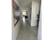 Hallway with tile flooring, large framed art, and view to living area at 8918 Tropical Haven Ct, Kissimmee, FL 34747
