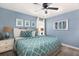 King-size bed with teal bedding and framed art in a light blue bedroom at 1540 Maidstone Ct, Davenport, FL 33896