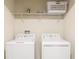 Convenient laundry room with washer, dryer, and shelving at 1540 Maidstone Ct, Davenport, FL 33896