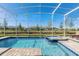 Screened pool and spa with plenty of lounge chairs and a view of the community at 1540 Maidstone Ct, Davenport, FL 33896