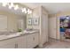 Double vanity bathroom with gray countertops and white cabinets, and a view of a bedroom at 1540 Maidstone Ct, Davenport, FL 33896