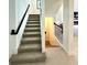 Modern staircase with dark wood railing and carpeting at 16779 Broadwater Ave, Winter Garden, FL 34787