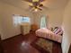 Bedroom with hardwood floors, large windows, and a pink comforter set at 252 Shady Oaks Cir, Lake Mary, FL 32746