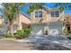 Tan two-story townhome with attached garage and landscaping at 2847 Metro Sevilla Dr # 105, Orlando, FL 32835