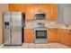 Stainless steel appliances and wood cabinets in kitchen at 2847 Metro Sevilla Dr # 105, Orlando, FL 32835