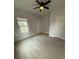 Well-lit bedroom with wood-look floors and window at 1009 Herndon St, Leesburg, FL 34748