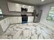 Modern kitchen with white cabinets, granite counters and stainless steel appliances at 1009 Herndon St, Leesburg, FL 34748