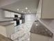 Modern kitchen with white cabinets, granite countertops, and stainless steel appliances at 1009 Herndon St, Leesburg, FL 34748