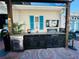Covered outdoor kitchen with grill, mini-fridge, and TV at 2025 St George Dr, Davenport, FL 33837