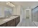 Double vanity bathroom with granite countertop and walk-in shower at 2468 Dubai St, Kissimmee, FL 34747