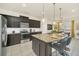 Spacious kitchen with dark cabinetry, granite island, and breakfast bar at 2468 Dubai St, Kissimmee, FL 34747