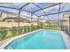 Screened-in pool with a relaxing lounge chair and lush green landscaping at 2468 Dubai St, Kissimmee, FL 34747