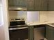 Modern kitchen with stainless steel appliances and dark green cabinets at 2850 N Powers Dr # 9, Orlando, FL 32818