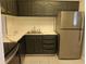 Modern kitchen with dark green cabinets, stainless steel appliances, and a white countertop at 2850 N Powers Dr # 9, Orlando, FL 32818