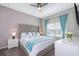 King-size bed with a gray headboard and teal bedding in a well-lit bedroom at 4819 Memories Ln, Kissimmee, FL 34746