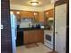 Modern kitchen featuring wood cabinets, granite countertops, and a full suite of appliances at 616 Georgetown Dr # B, Casselberry, FL 32707