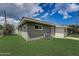 Green house exterior with white trim, landscaping, and a spacious yard at 213 Sandy Cir, South Daytona, FL 32119