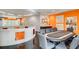 Game room with a poker table, wet bar, and vibrant orange accent wall at 2550 Venetian Way, Winter Park, FL 32789