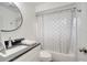 Clean bathroom with white vanity, dark countertop and shower/tub combo at 5125 Formby Dr, Orlando, FL 32812