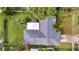 House with gray roof and a detached structure, surrounded by lush green landscaping at 5125 Formby Dr, Orlando, FL 32812