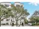 Modern building exterior with tree-lined street at 204 E South St # 1055, Orlando, FL 32801