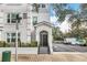 Exterior view of a light gray building with a black door, steps, and landscaping at 204 E South St # 1055, Orlando, FL 32801