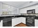 Modern kitchen with black appliances, white cabinets, and dark granite countertops at 204 E South St # 1055, Orlando, FL 32801