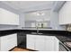 Modern kitchen with black appliances, white cabinets, and dark granite countertops at 204 E South St # 1055, Orlando, FL 32801