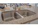 Modern kitchen featuring a double stainless steel sink and granite countertops at 4185 Singing Mockingbird Blvd, Bartow, FL 33830