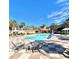 Community pool with lounge chairs and umbrellas at 8575 Bay Lilly Loop, Kissimmee, FL 34747