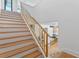 Elegant staircase with light wood steps and gold railing, kitchen view at 1948 Rowena Ave, Orlando, FL 32803