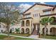 Three-story townhome with stucco exterior, arched entryways, and palm trees at 2108 Lobelia Dr, Lake Mary, FL 32746