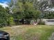 Large backyard with mature trees, shed, and grassy area at 2109 Morning Dr, Orlando, FL 32809